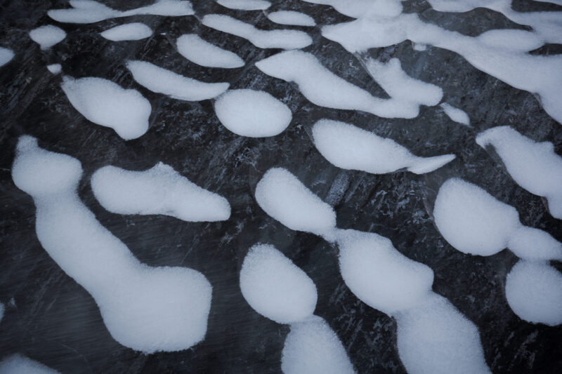 Schneeflecken auf schwarzem Eis, Vatnajökull Nationalpark, Island