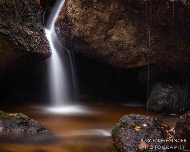 Kreativer Fotoworkshop in der Ysperklamm im Herbst, Niederösterreich. Fotografen bei der Arbeit an Wasserfällen, moosbewachsenen Felsen und idyllischen Landschaften.
