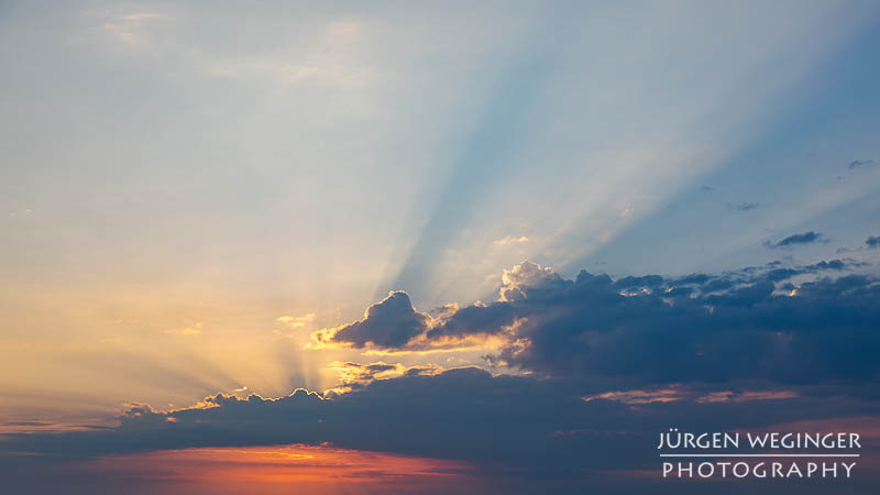 Sonnenlicht zwischen dunklen Wolken am frühen Morgen