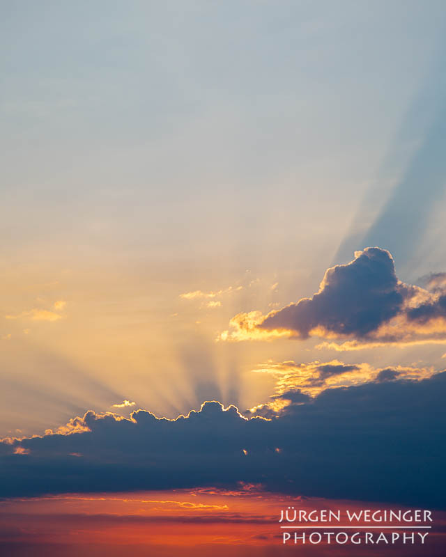 Sonnenlicht zwischen dunklen Wolken am frühen Morgen