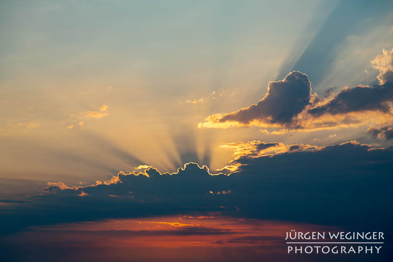 Sonnenlicht zwischen dunklen Wolken am frühen Morgen