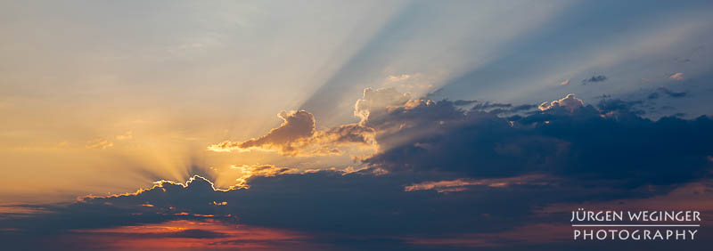 Sonnenlicht zwischen dunklen Wolken am frühen Morgen