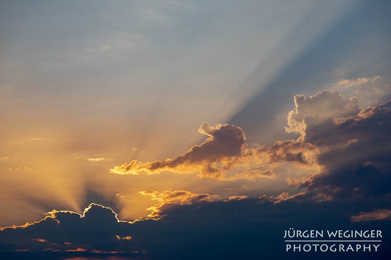 Sonnenaufgang, Sonne hinter den Wolken mit blauen Himmel darüber